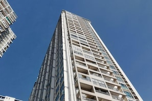 A high-rise building with multiple balconies, a clear sky, and a modern architectural design. - Shenzhen Four Seasons Family Apartment (Shenzhen)