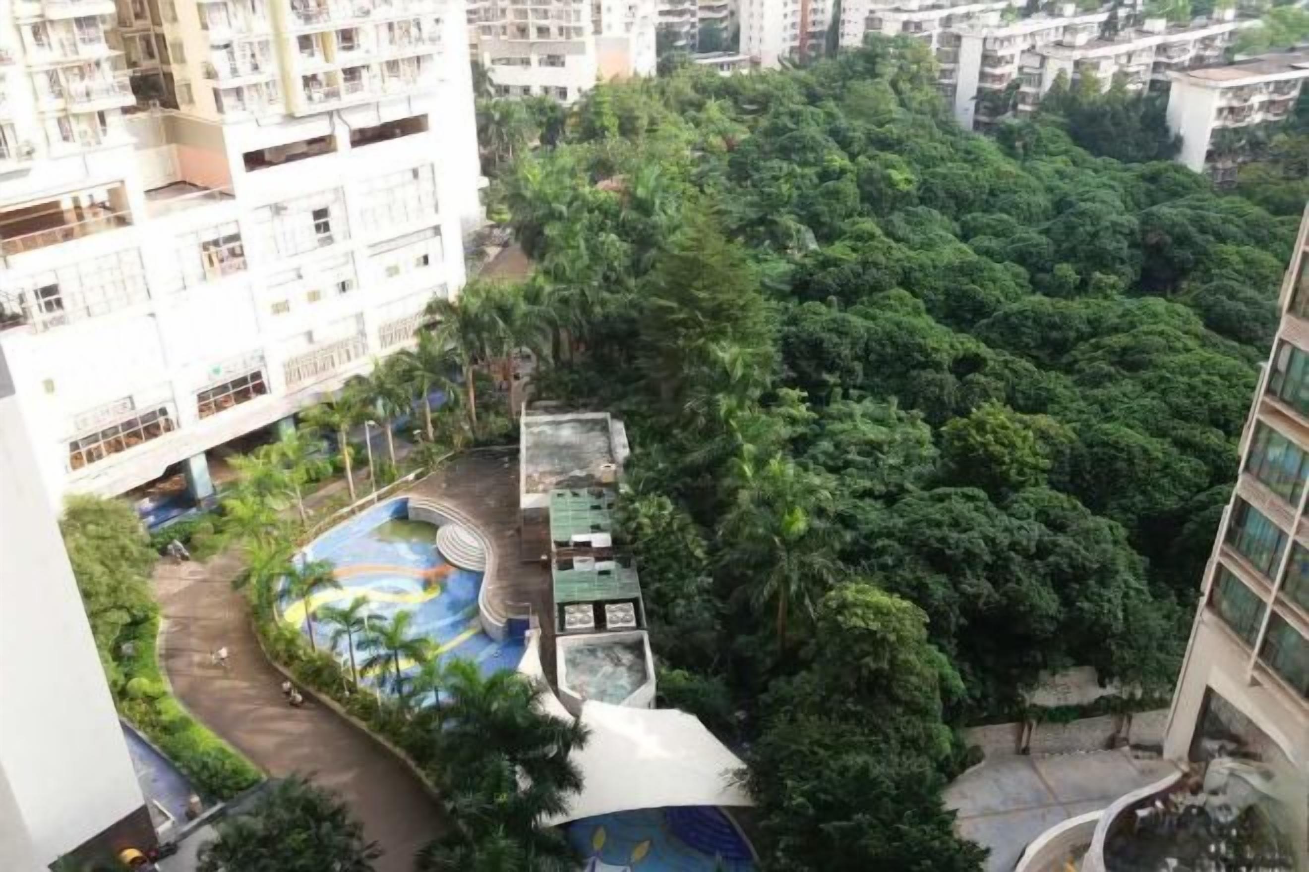 A high-rise building with a rooftop garden and a swimming pool.