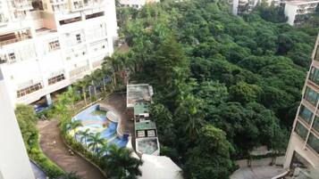 A high-rise building with a rooftop garden and a swimming pool.