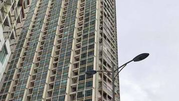 Um edifício alto com uma fachada em grade e um poste de luz na frente.