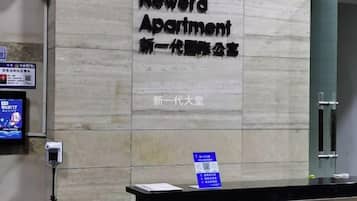 A reception desk with a sign for Newera Apartment.