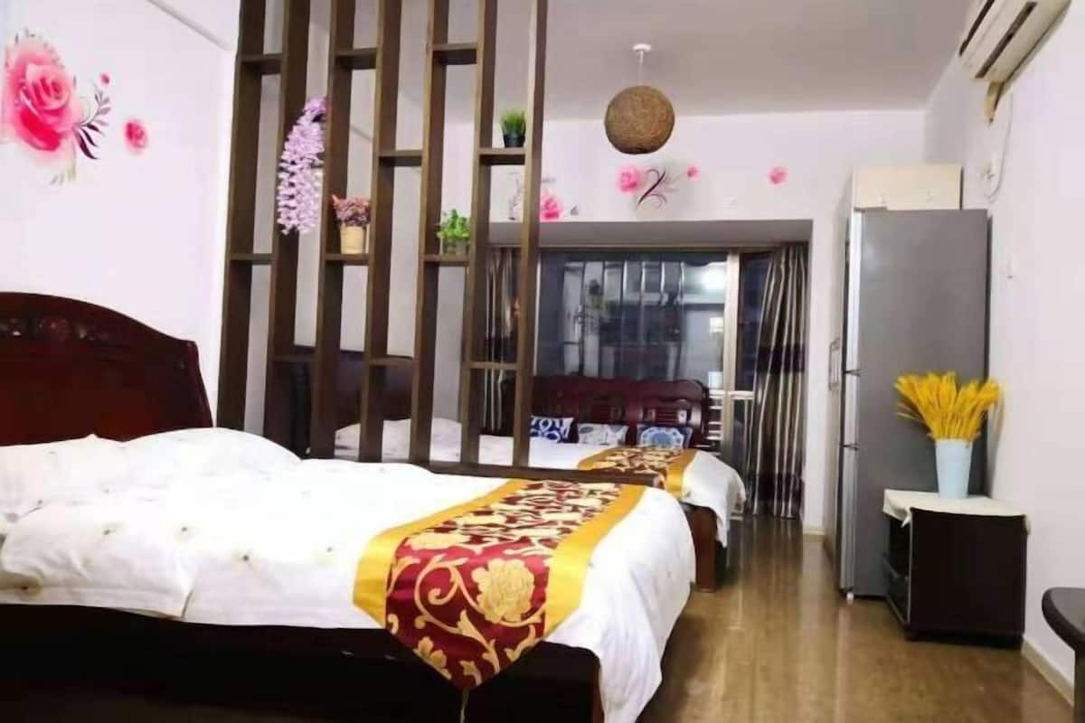 A bedroom with a bed, a wardrobe, a desk, and a chair.