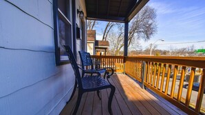 A wooden deck with a railing, a chair, and a window. - ★ Cozy Escape★ Central Home ★ Plaza KC (Kansas City)
