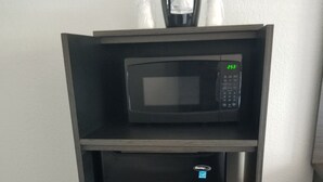 A compact black refrigerator with a digital display and a microwave on top. - Motel 6 Sacramento, CA - Natomas & SMF Airport (Sacramento)