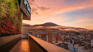 A hotel with a view of a cityscape and a mountain in the background. - Hotel V1501 (San Juan de Pasto)
