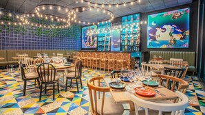 A restaurant with a colorful geometric floor pattern, wooden chairs, and tables set for dining. - Hotel V1501 (San Juan de Pasto)
