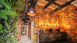A bar area with a counter, stools, and a wall decorated with movie posters. - Hotel V1501 (San Juan de Pasto)