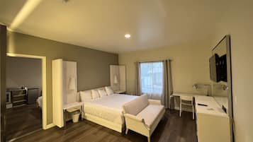 A modern hotel room with a large bed, a desk, and a bathroom.