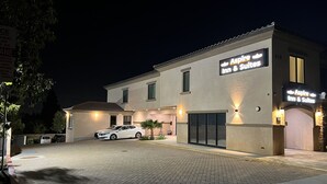 A building with a sign for 'Aspire Inn & Suites' at night. - Aspire Inn & Suites Orange (Orange)