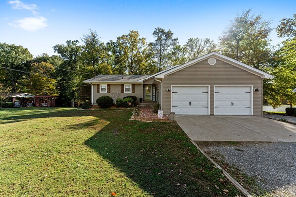 A two-story house with a garage, a front porch, and a well-maintained lawn. - 3 bedroom/2 full bath lakefront home with gentle slope to private covered dock (Cadiz)