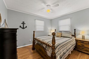 A bedroom with a wooden bed, a ceiling fan, and a dresser. - 3 bedroom/2 full bath lakefront home with gentle slope to private covered dock (Cadiz)