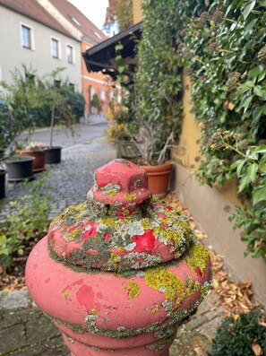 Situated on a cobblestone path, this historic fire hydrant stands amidst lush greenery.