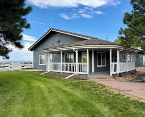 A two-story house with a covered porch and a fenced yard. - FARMHOUSE W/MOUNTAIN VIEWS! (Parker)