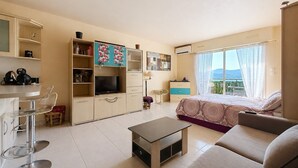Een moderne woonkamer met een bank, een salontafel, een televisie en een balkon met uitzicht.