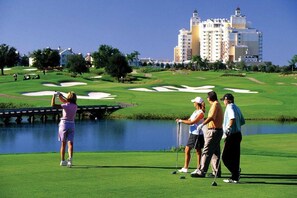 A golf course with a water hazard, a bridge, and a large hotel in the background. - 3/2 Close to Disney and theme parks (reunion)