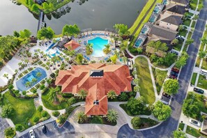 An aerial view of a resort with a swimming pool, tennis courts, and a large building with a red roof. - Comfort Single Home with BBQ, Private Pool & Hot Tub (Kissimmee)