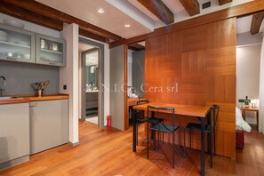 A modern kitchen with a wooden countertop, built-in cabinets, and a dining area with a wooden table and chairs.