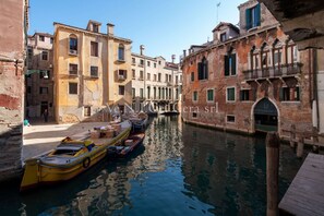 A narrow canal in Venice with boats docked along the sides.