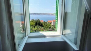 A view from a window with a clear view of the sea and a distant coastline. - Holiday apartment with two bedrooms and sea views (Jadranovo)