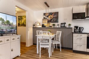 Una cocina moderna con comedor, armarios de madera y un televisor de pantalla plana.