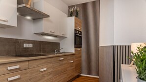 Une cuisine moderne avec des meubles en bois, un évier en acier inoxydable et un four encastré.