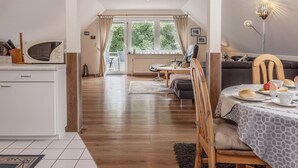 Una cocina moderna con microondas, mesa de comedor dispuesta para el desayuno y vistas al exterior a través de ventanas amplias.