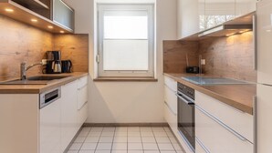 A compact kitchen with a window, built-in shelves, a coffee maker, and a radio. - Open and flooded with light: the first floor apartment with its 62 square meters was brightly (Wittmund)