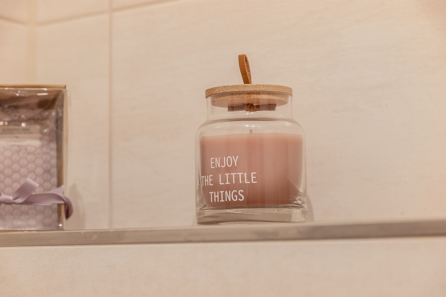 A glass jar with a cork lid and a label that reads "ENJOY THE LITTLE THINGS."