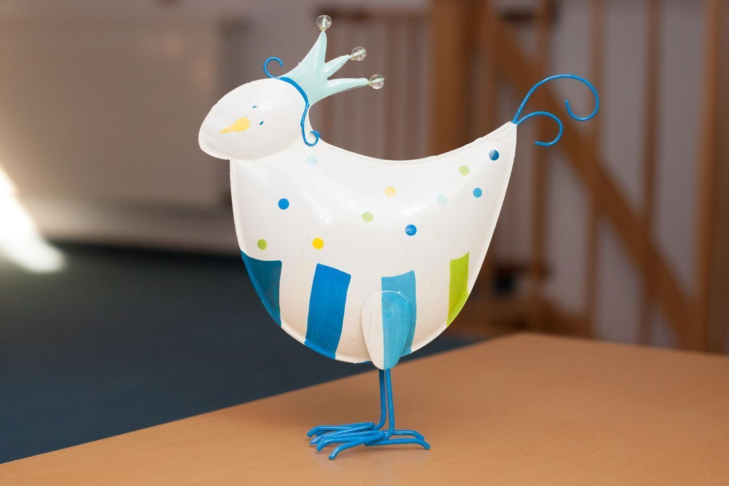 A decorative ceramic bird with a crown and colorful accents.