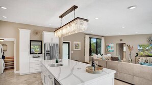 A modern kitchen with a large island, stainless steel appliances, and a chandelier. - Private Waterfront Home in Wilton Manors - Dock & BBQ - Minutes From The Beach (Wilton Manors)