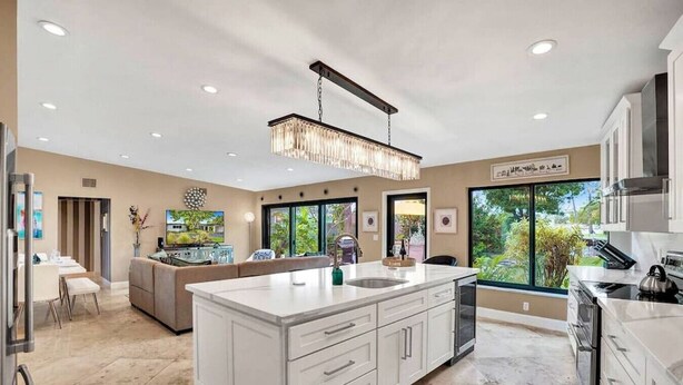 A spacious kitchen with a large island, modern appliances, and large windows offering a view of the outdoors. - Private Waterfront Home in Wilton Manors - Dock & BBQ - Minutes From The Beach (Wilton Manors)