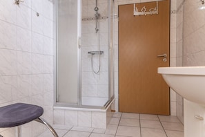 Et badeværelse med bruser, toilet og vask.