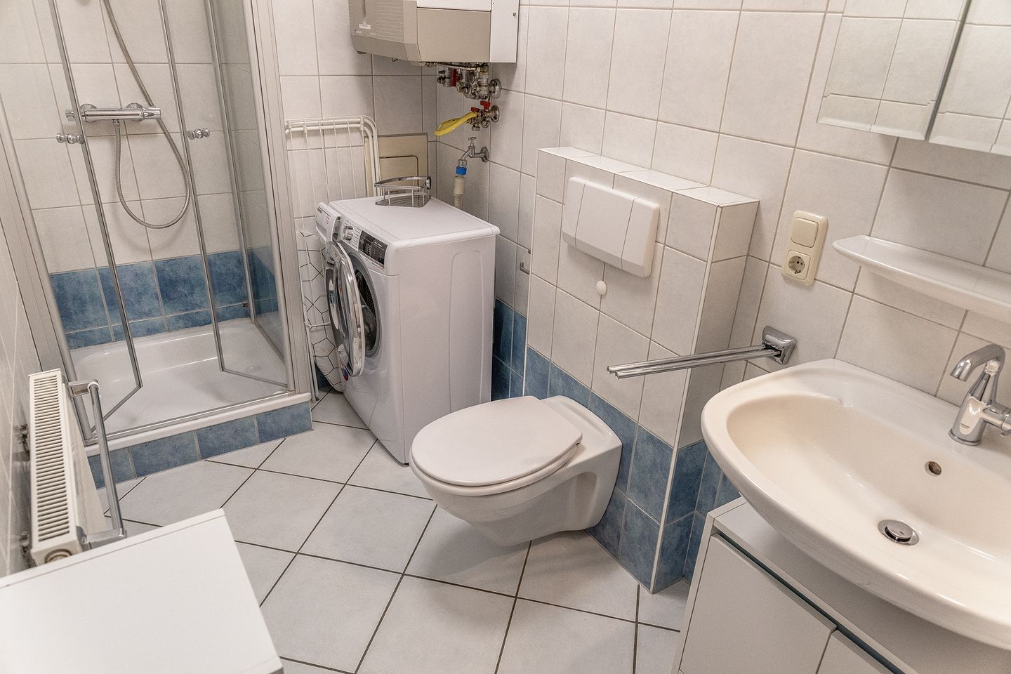 Ein Badezimmer mit Dusche, Toilette und Waschbecken.