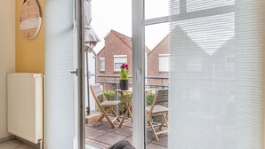 Ein Balkon mit Tisch, Stühlen und einer Topfpflanze.