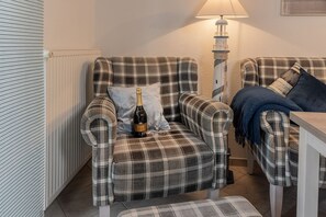 A cozy living room with a plaid sofa, a small table, and a lamp. - Vacation apartment 50160 - Cute and flooded with light: the first floor apartment is (Wittmund)