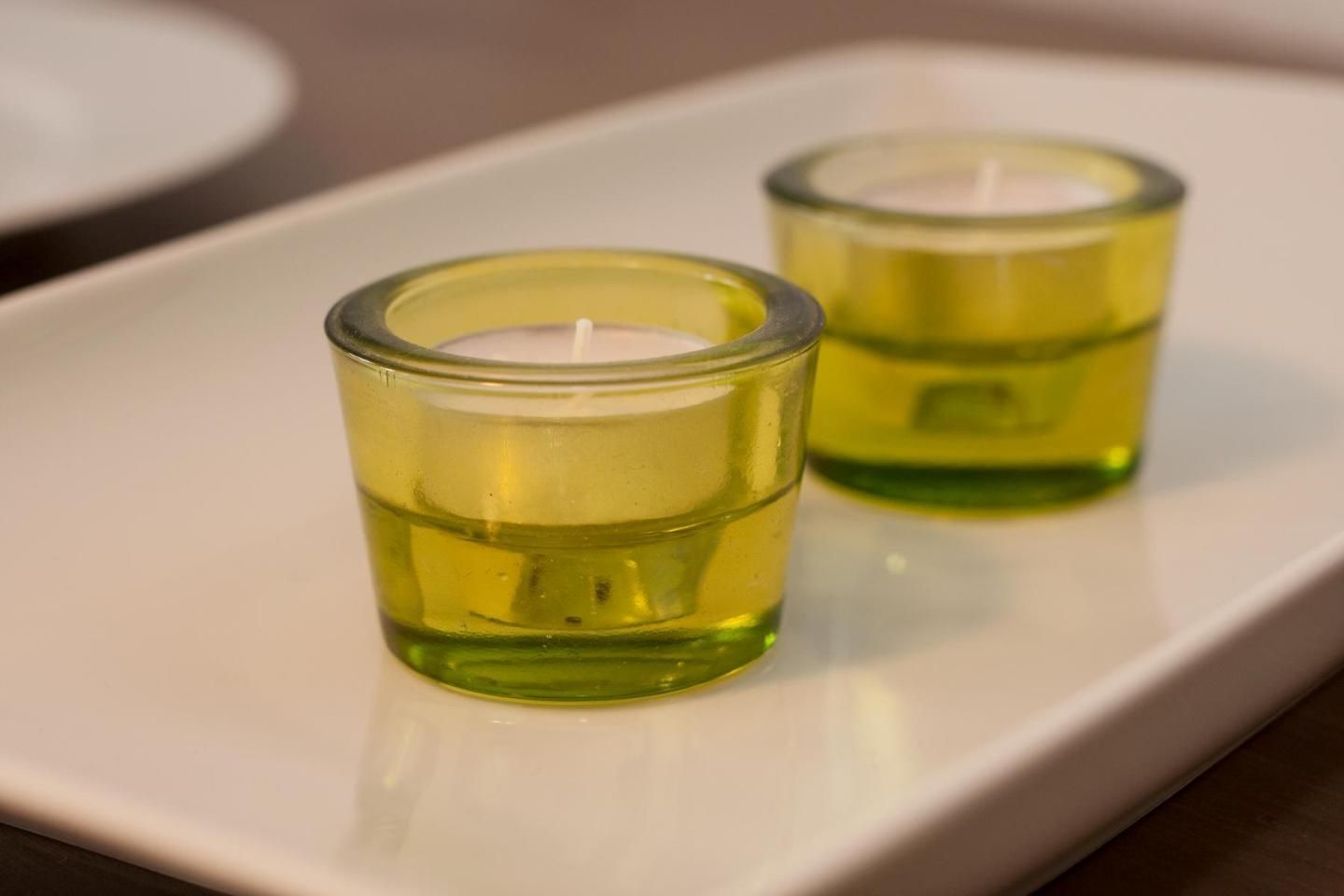 Two small glass candle holders on a white rectangular tray.