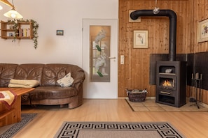 Uma sala de estar aconchegante com sofá de couro, lareira e parede de madeira.
