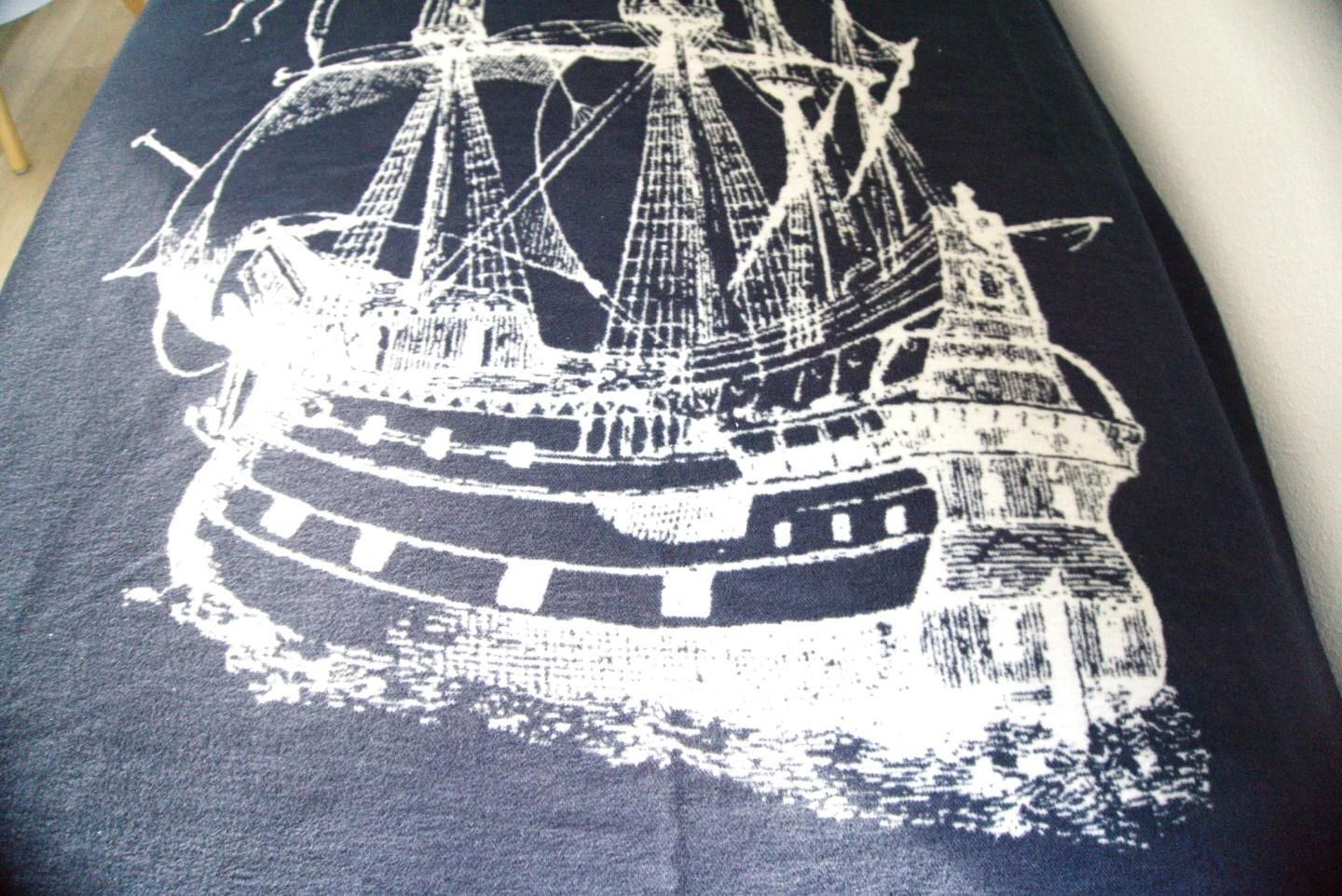 Une nappe noire ornée d’une illustration représentant un navire blanc.