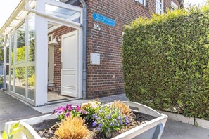 En bygning med et blåt skilt der siger 'Haus Wathwurm' og nummeret '12b'.