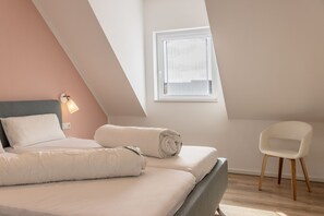 Une chambre à coucher avec un lit, une chaise et une fenêtre.