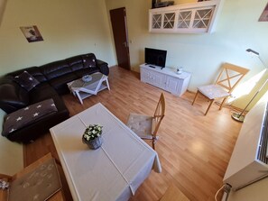 A living room with a sofa, a coffee table, a TV, a cabinet, and a chair.