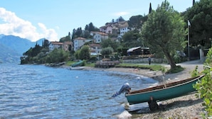 Vista lacustre con casas, un muelle y un barco.
