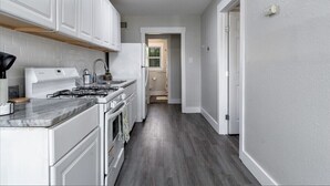 A modern kitchen with white cabinetry, a gas stove, and a built-in oven. - Central 1BDR+RemoteWork+Extended Stay+Pets OK (Corpus Christi)