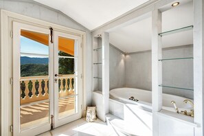 A modern bathroom with a large bathtub, glass shelves, and a view of the outdoors. - Beautiful private villa for 14 people with A/C, private pool, WIFI (Montecatini Terme)