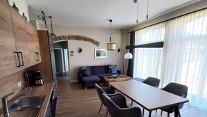 Eine moderne Küche mit Holzausbau, einem eingebauten Ofen und einem Essbereich mit Tisch und Stühlen.