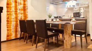 A modern kitchen with a dining area, featuring a wooden table, chairs, and a unique wall design.
