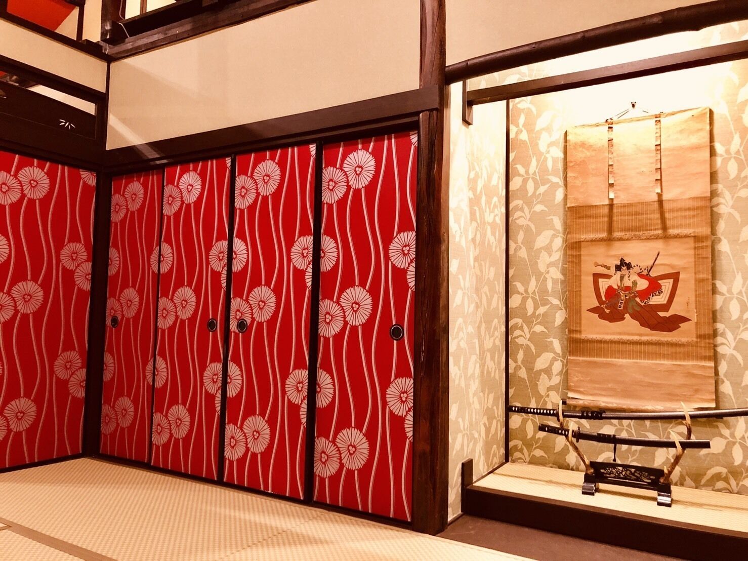 A traditional Japanese room with sliding doors featuring a red and white floral pattern.