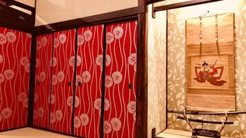 A traditional Japanese room with sliding doors featuring a red and white floral pattern.