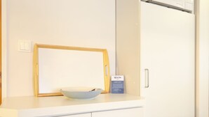 A white kitchen counter with a bowl, a framed picture, and a sign. - Rochts - House Rolf - Apartment Rochts (Sylt)