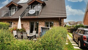 A two-story house with a balcony, a sign reading "Syle to Hus," and a car parked in the driveway. - Lille Kamp 1, Germany (Sylt-Ost)